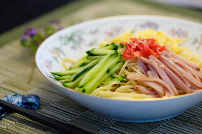 cold noodles with cucumbers and mushrooms on top